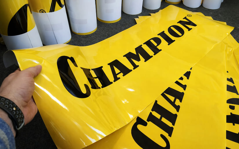 Печать глянцевых наклеек для автомобильной компании "Champion" по цене от 200 руб/м2, заказать дешево в Москве🔥